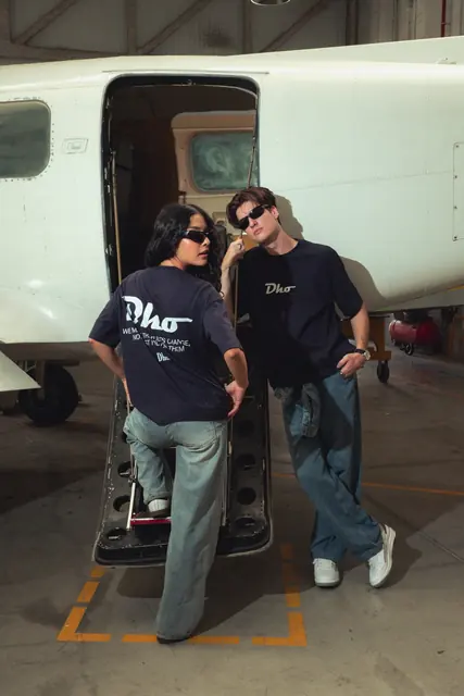Dos modelos con ropa de Dho junto a una avioneta