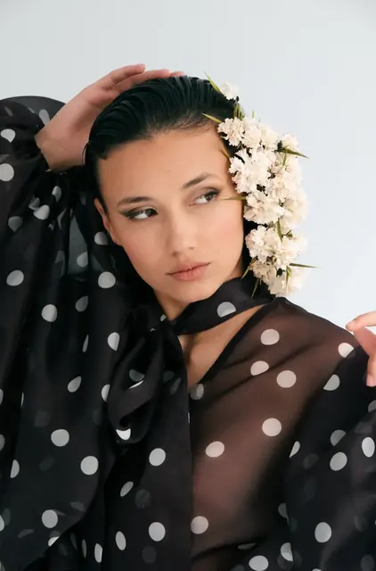 Retrato de moda con vestido de lunares y flores en el pelo